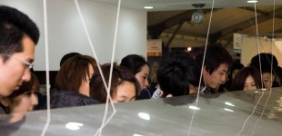A crowd of people look at an exhibit at 100% Design Tokyo