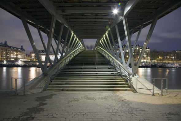 A modern wooden footbridge across the Seine in Paris.