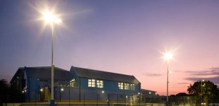 Exterior of the sports centre at night from the football pitch